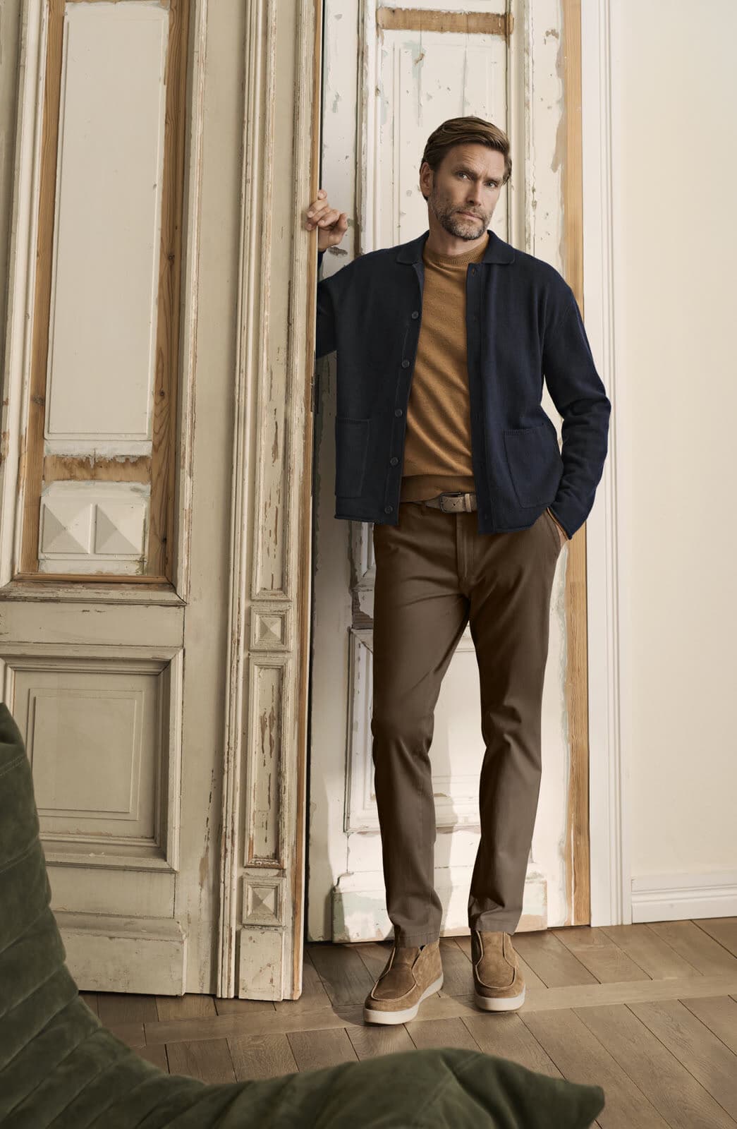Man in een Eurex by Brax broek en colbert in een deuropening